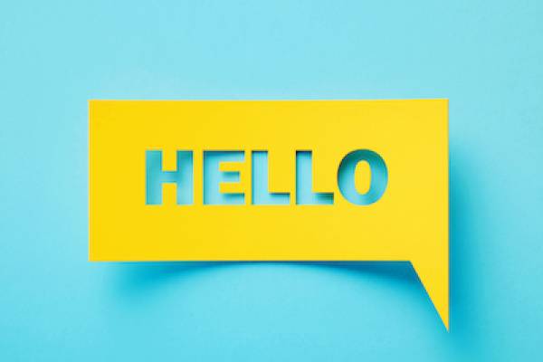 turquoise background, yellow paper on top with the word "hello" cut out