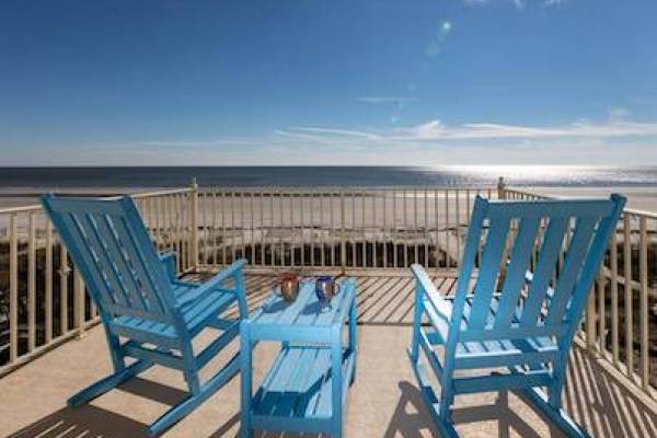 blue rocking chairs on a balcony facing the ocean in Hilton Head