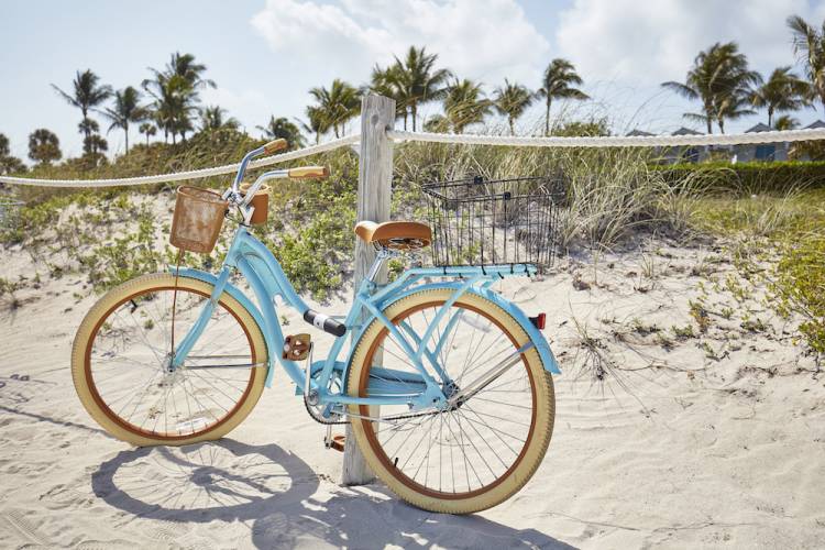 bike propped against rope fence at beach