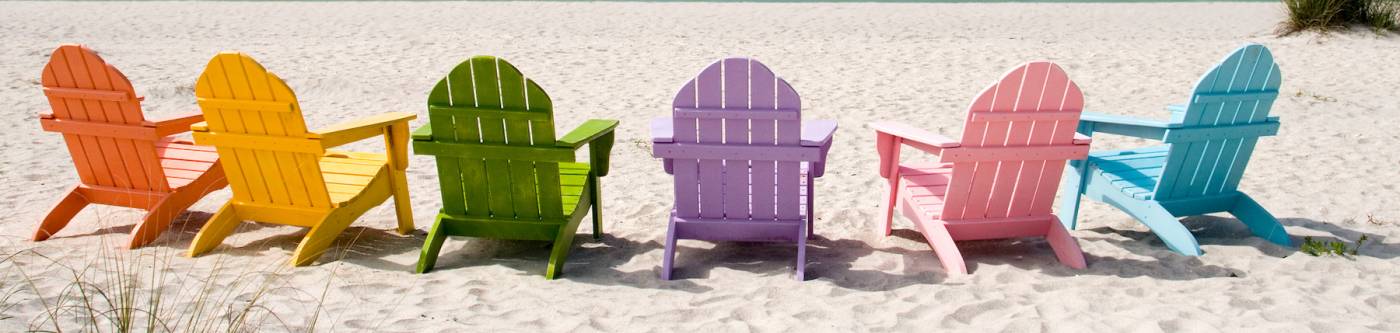 rainbow Adirondack chairs on the beach  
