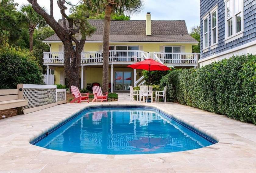 in-ground pool with view of back porch of a hilton head home