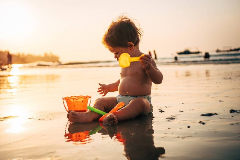 baby playing in sand on beach