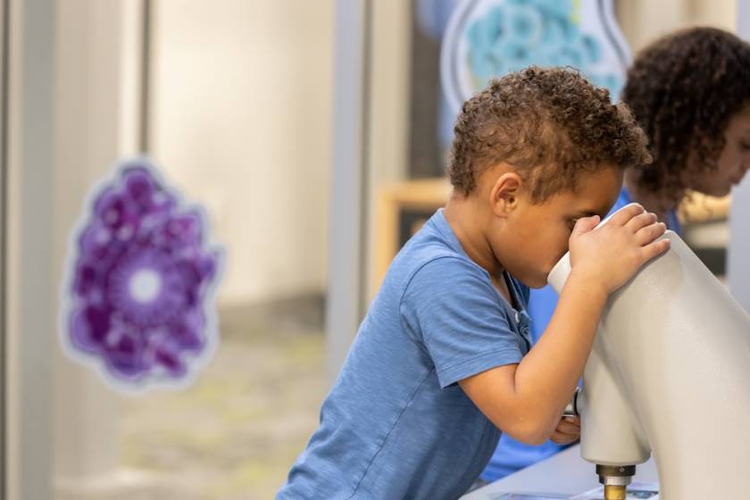 child looking through view finder at kid's museum