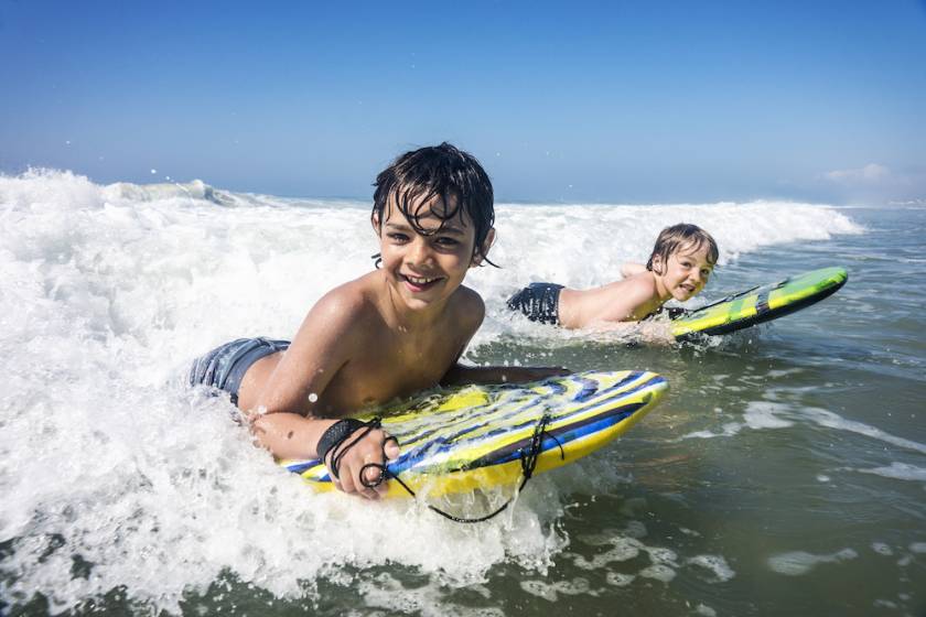 kids on boogie boards in ocean